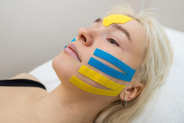 Facial tape closeup of a girl's face with an antiwrinkle cosmetology tape Aesthetic taping of the face Noninvasive antiaging lifting method to reduce wrinkles