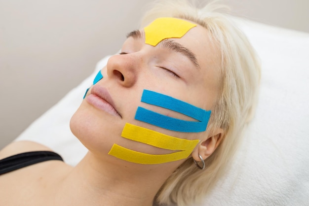 Facial tape closeup of a girl's face with an antiwrinkle cosmetology tape Aesthetic taping of the face Noninvasive antiaging lifting method to reduce wrinkles