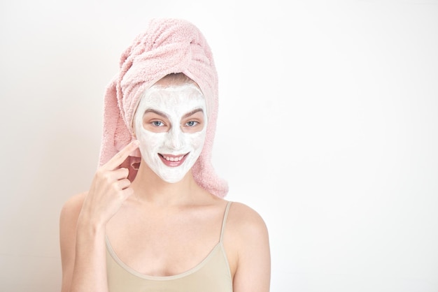 Facials. A girl with a towel on his head and a mask on her face