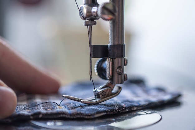 Factory production of clothing. Close up image of a sew machine in use.