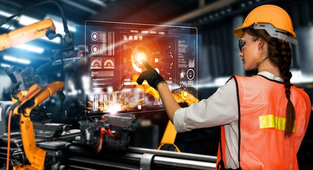 Factory worker control robotic arm in factory