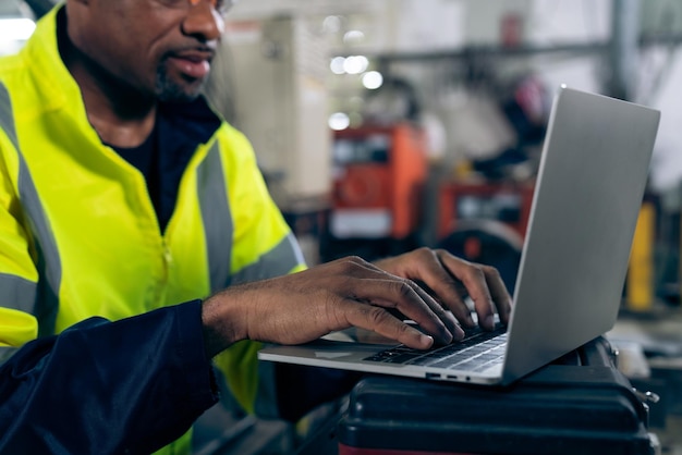 Factory worker working with laptop computer to do adept procedure checklist