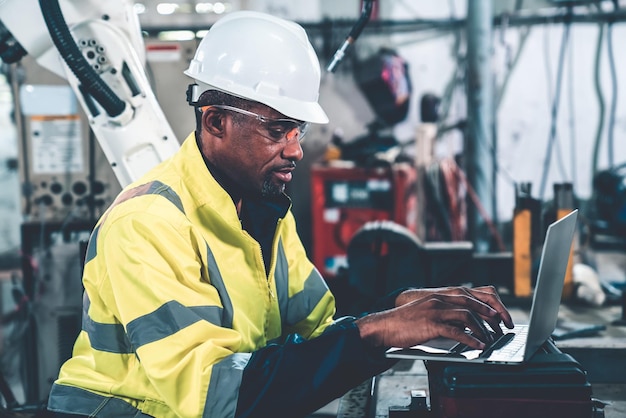 Factory worker working with laptop computer to do adept procedure checklist