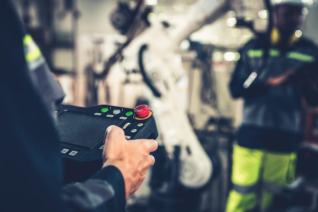 Factory workers working with adept robotic arm in a workshop