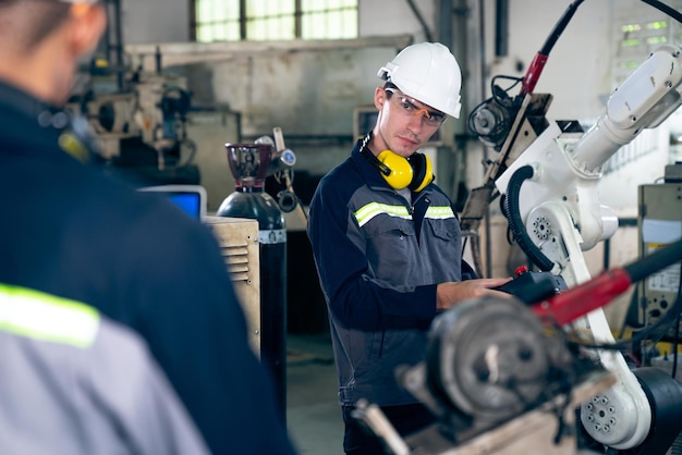 Factory workers working with adept robotic arm in a workshop