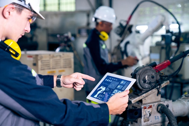 Factory workers working with adept robotic arm in a workshop