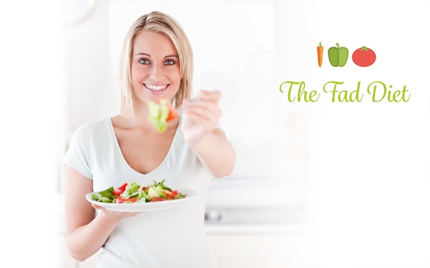 Photo the fad diet against close up of a good looking woman eating salad