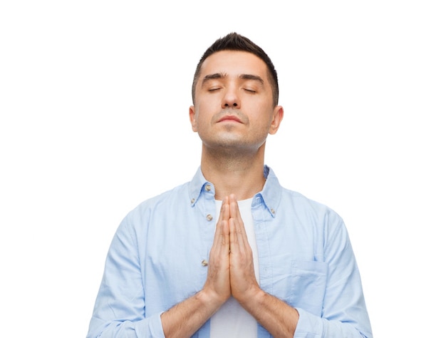 faith in god, religion and people concept - happy man with closed eyes praying