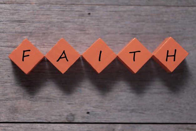 Faith symbol Turned wooden cube with words Faith Beautiful wooden table background Business and Faith concept Copy space