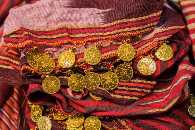 Fake gold coins are on the scarf edges