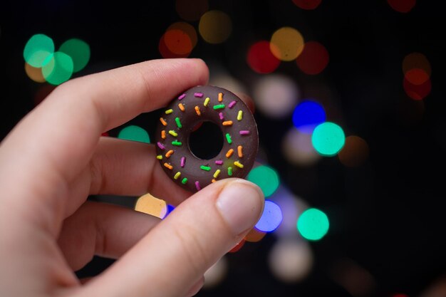 Fake model of sweet colorful donut in hand Dessert pastry donuts design for menu advertising poster of cafe bakery