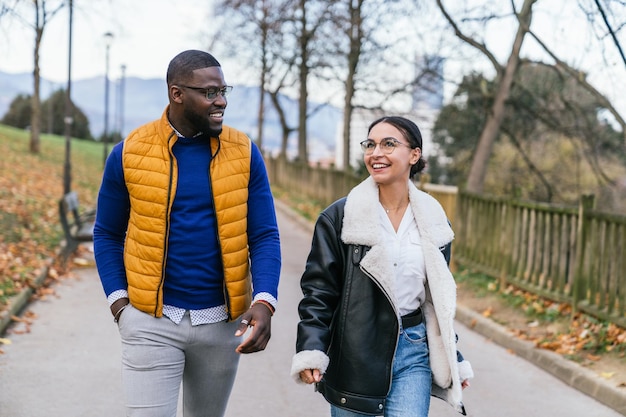 Fall Foliage Friendship A Black Boy and Caucasian Girl Walking Towards Each Other Smiling and Connecting in a Casual Lifestyle Setting