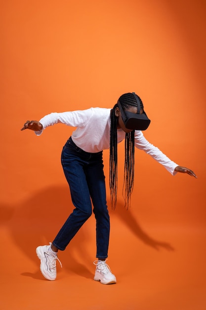 Falling African American girl with vr glasses holding her arms out to her sides