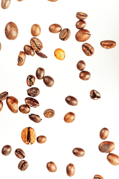 Falling coffee beans isolated on white background, clipping path, full depth of field. Cereal product. Hot drink. Close up. Harvesting. Natural background. Energy. Flying,vertical orientation