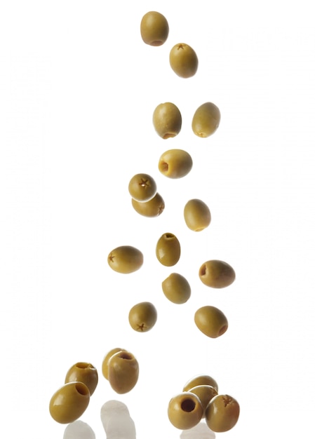 Falling olives on white surface