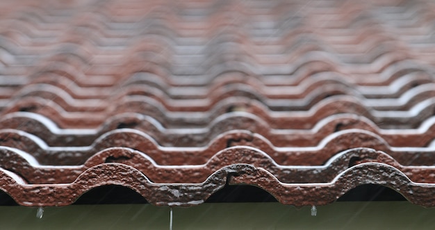 Falling Rain drop on brown brick roof