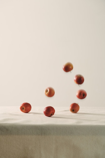 Falling red apples on table background