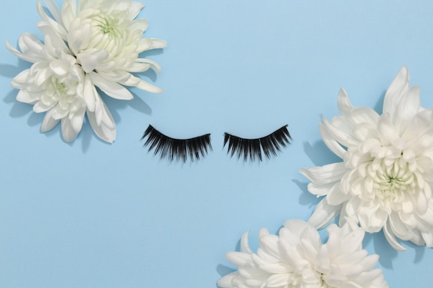 False eyelashes extensions black on blue background with flowers