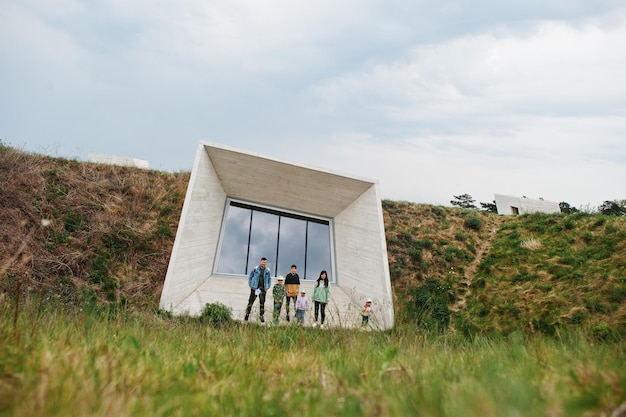 Family against modern futuristic building stone wall with window outdoor