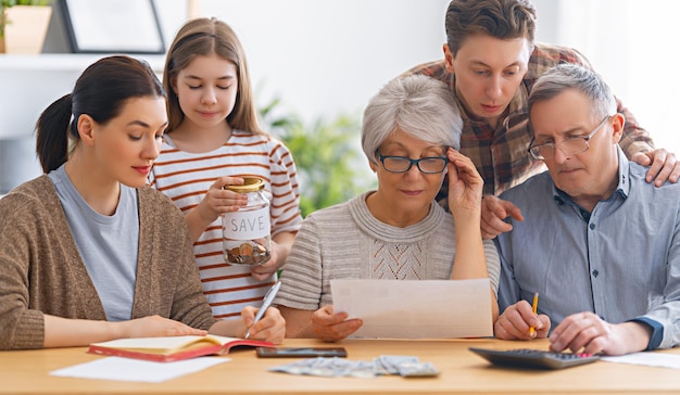 Family are sitting at a desk with a paper receipt and calculating expenses, managing budget.