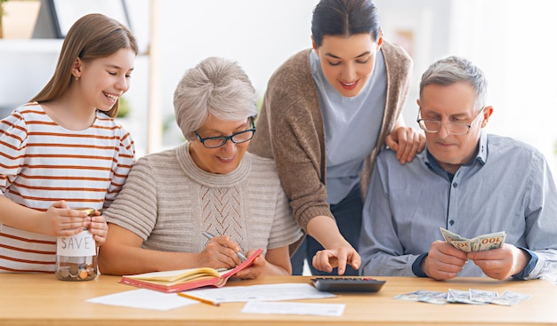 Family are sitting at a desk with a paper receipt and calculating expenses, managing  budget.