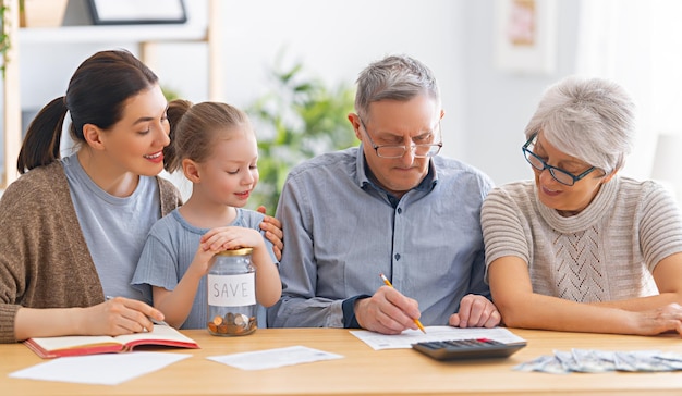 Family are sitting at a desk with a paper receipt and calculating expenses, managing  budget.