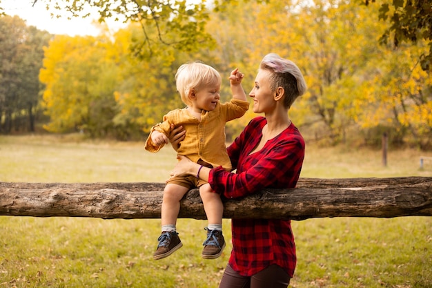 Family in autumn park Mom playing with son child in summer