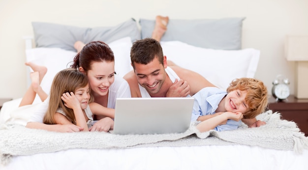 Family in bed using a laptop