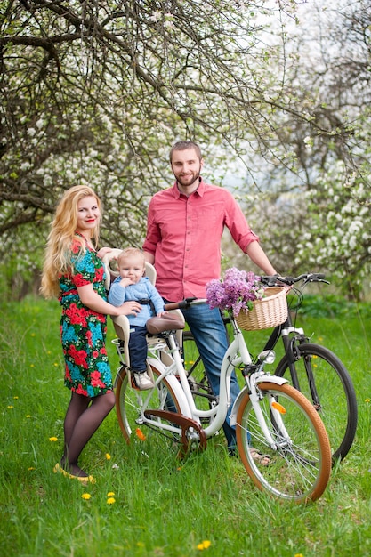 Family on a bicycles in the spring garden