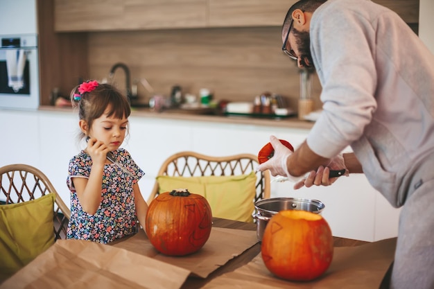 Family carving pumpkins together for Halloween