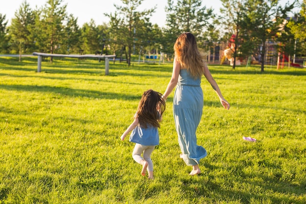 Family and child concept  mother and daughter walking in the park and enjoying the beautiful nature