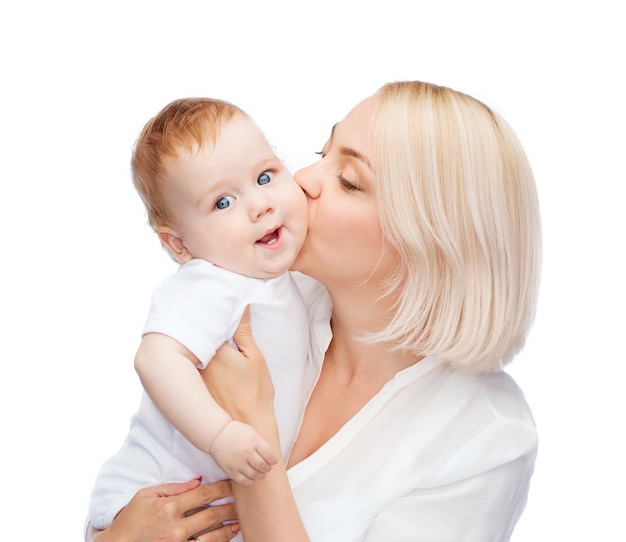 family, child and parenthood concept - happy mother kissing smiling baby