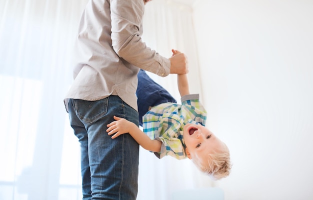 family, childhood, fatherhood, leisure and people concept - happy father and little son playing and having fun at home