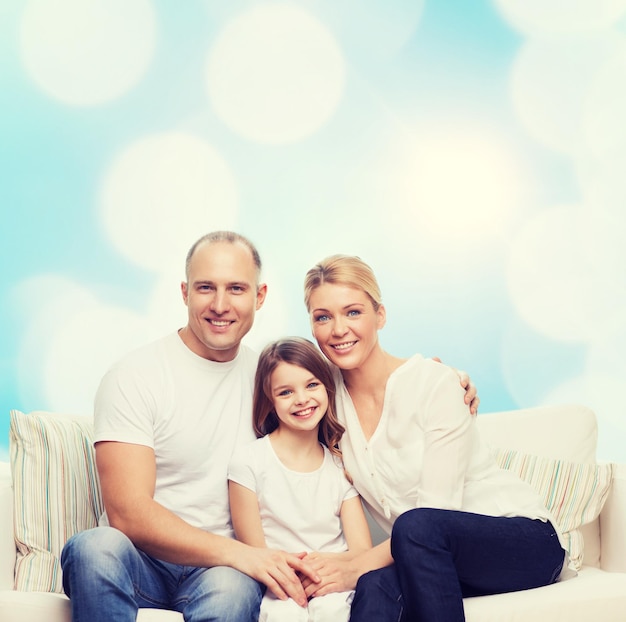 family, childhood, holidays and people concept - smiling mother, father and little girl over blue lights background