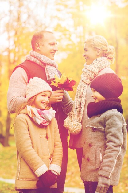 family, childhood, season and people concept - happy family in autumn park