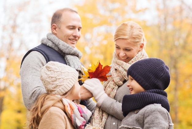 family, childhood, season and people concept - happy family in autumn park