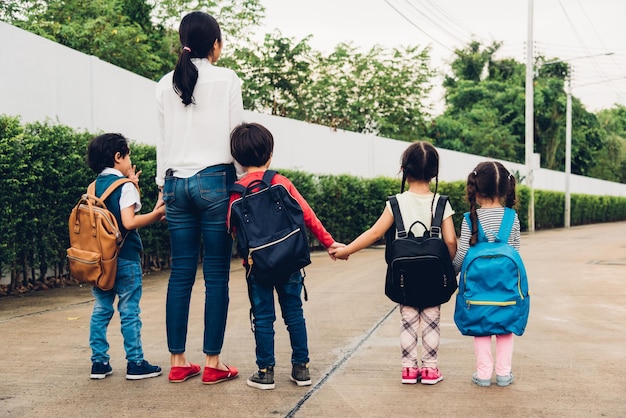 Family children kid son girl and boy kindergarten walking going to school holding hand with mother mom