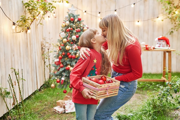 Family Christmas in July Portrait of girl near christmas tree with gifts Decorating pine Winter