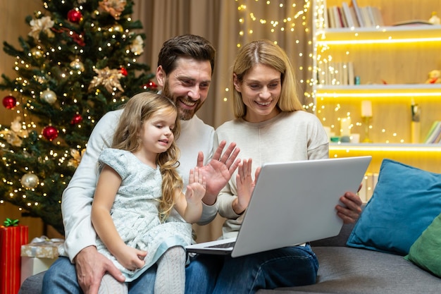 Family on christmas talking with friends and online greetings and family on video call man woman and