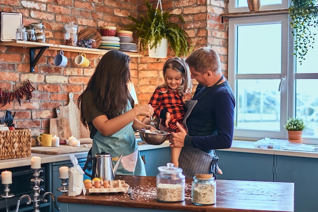 Family concept. Adorable family together cooking breakfast in loft style kitchen.