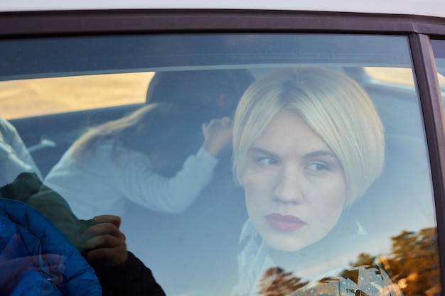 Family concept Portrait of mother and daughter through the glass of a car