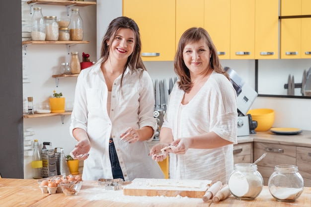 Family cooking and communicating in kitchen. Mother and daughter together