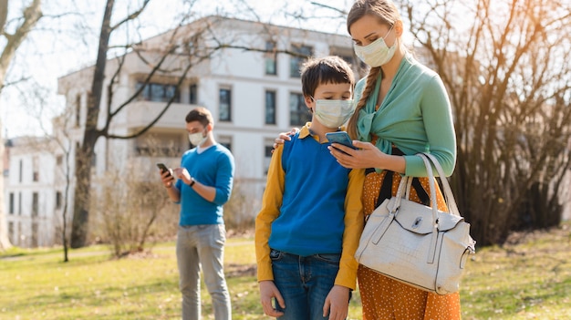 Family during corona crisis checking news on their phones