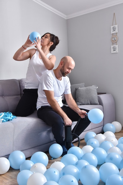 Family couple blowing blue and white balloons