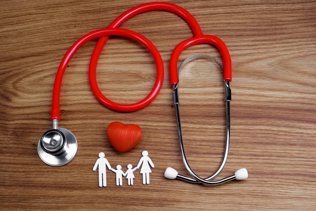 Family cutout and Stethoscope on wooden table