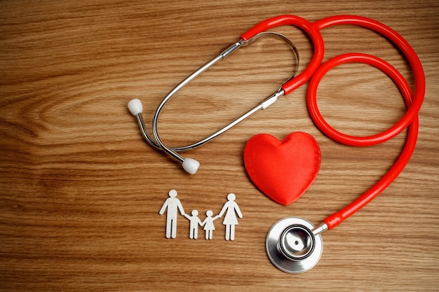 Family cutout and Stethoscope on wooden table