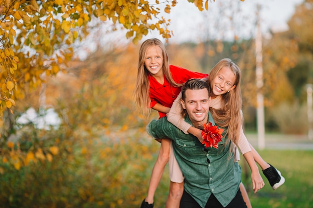 Photo family of dad and kids on beautiful autumn day in the park