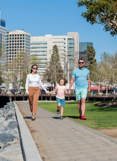 Family day friendship father mother and child walking in park friendly family having fun in summer happy parents with kid boy mom dad and son love relax together adoption and charity