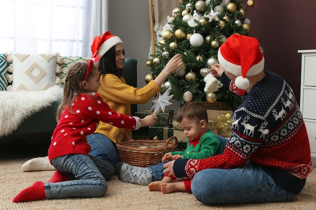 Family decorating beautiful Christmas tree at home