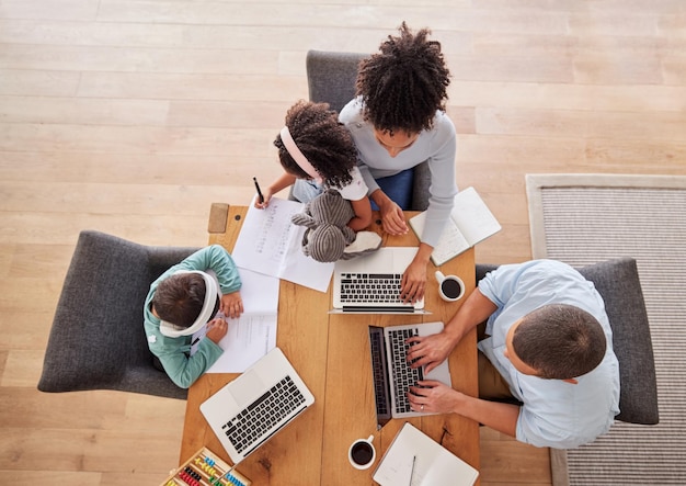 Family desk and laptop for work in living room parents children and education Black woman man and kids together in house working on computer for homework online job and learning above